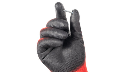 Black and red glove holding a small metal object on a white background