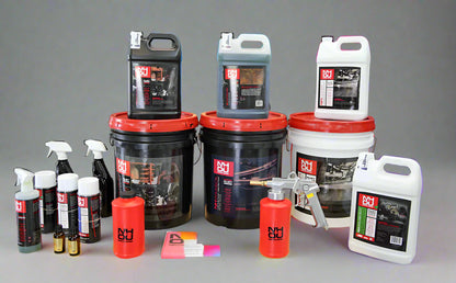 Collection of automotive care products including bottles, buckets, and cans on a gray background