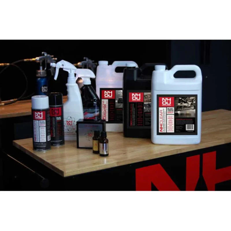 Collection of cleaning products on a wooden surface with a black background